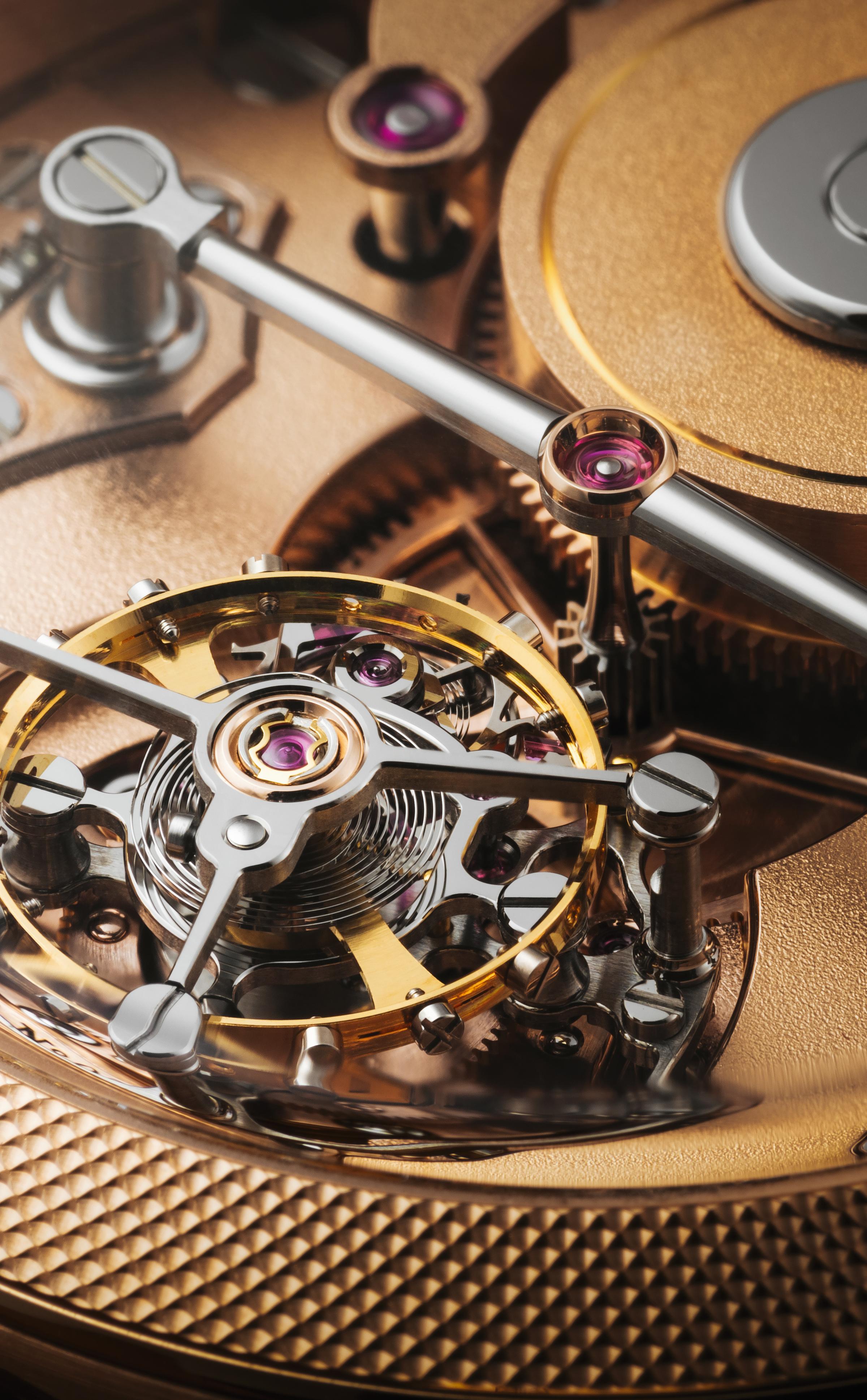 Close-up of a high-end mechanical watch movement showing the balance wheel, bridge, and polished components with gold and steel finishes.